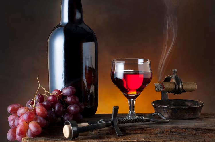 cigar advisor top 10 cigars and red wine pairings wine bottle grapes and glass with a cigar burning next to it
