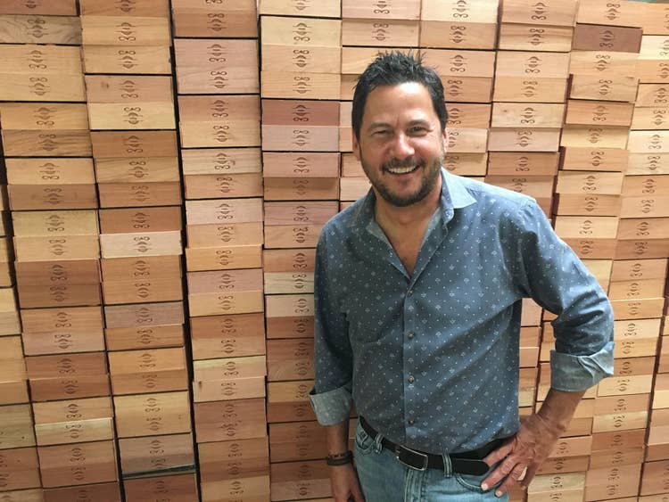 cigar advisor cao cigars essential tasting guide - rick rodriguez standing in front of CAO boxes
