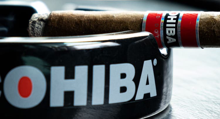 cigar advisor essential guide to cohiba - cohiba cigar sitting on a cohiba ashtray