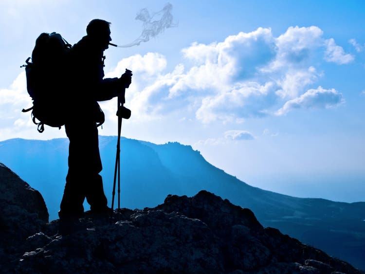 cigar advisor 5 things about traveling with cigars - hiker smoking in the mountains
