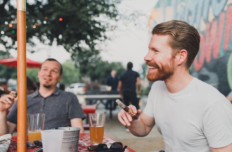 man enjoying cigar with friends