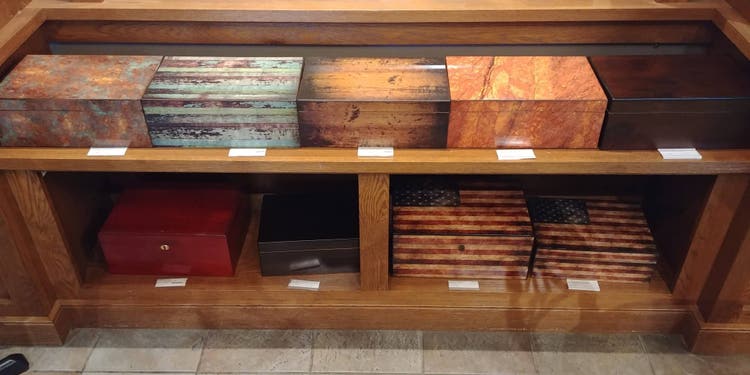 a group of humidors on the shelf at famous smoke shop
