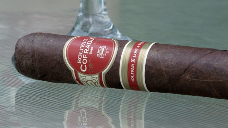 cigar advisor #nowsmoking Cigar Review Bolivar Cofradia Lost and Found - cigar and wine glass on a glass table top - at Famous Smoke Shop