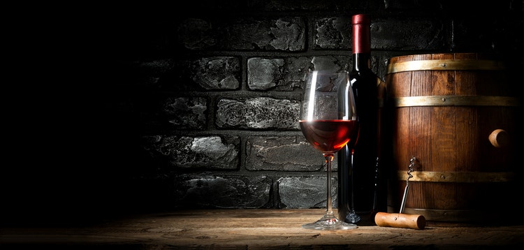 cigar advisor top 10 cigars and red wine pairingswine glass, bottle, and barrel in front of a stone wall
