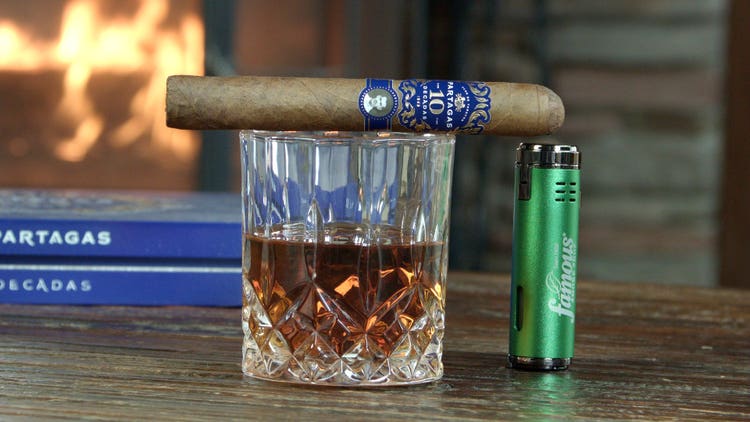 cigar advisor #nowsmoking cigar review of partagas limited reserve decadas 2021 - cigar on top of whiskey glass with lighter and box