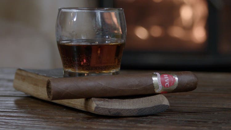 cigar advisor #nowsmoking hvc seleccion no. 1 cigar review - setup shot of cigar on a whisky stave with a whiksy and a fireplace in the background
