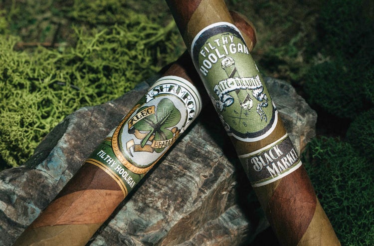 cigar advisor news - alec bradley filthy hooligan 2022 release - shot of cigars on a stone and grass background