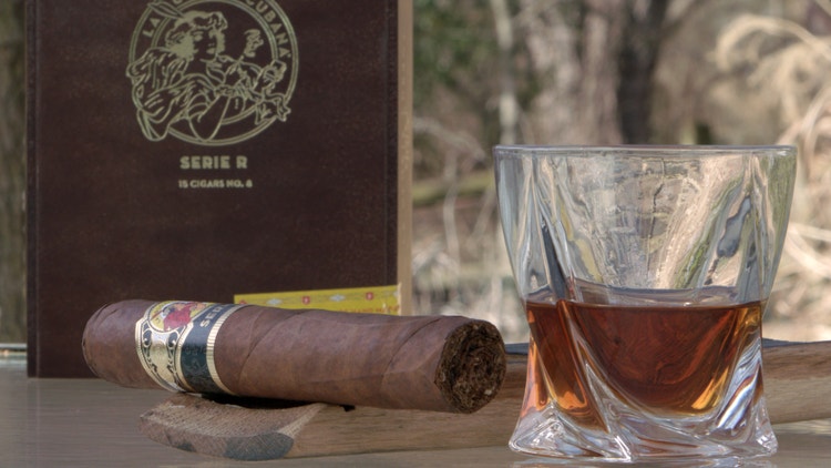 cigar advisor #nowsmoking cigar review of la gloria cubana serie r no. 8 (7" x 70) - cigar with box in background next to whiskey glass