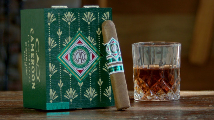 cigar advisor #nowsmoking cigar review of cao cameroon l'anniversaire - shot of whiskey and cigar in front of its box