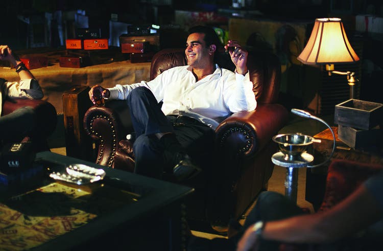 cigar advisor master blenders christian eiroa of c.l.e. cigars - sitting in a lounge and smoking a cigar