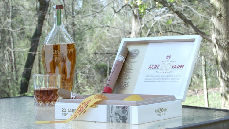 cigar advisor #nowsmoking cigar review 20 acre farm drew estate - cigar resting on box with whiskey glass and bottle in background