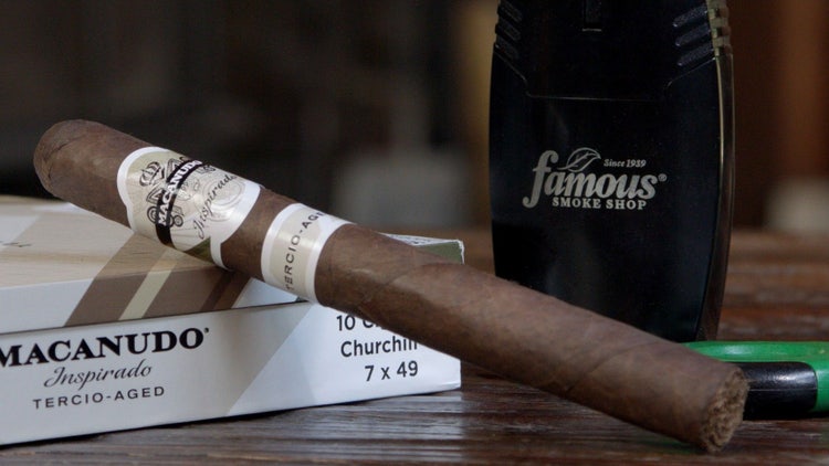 cigar advisor #nowsmoking cigar review macanudo inspirado terico-aged setup shot of cigar leaning on its box with famous smoke shop lighter in the background