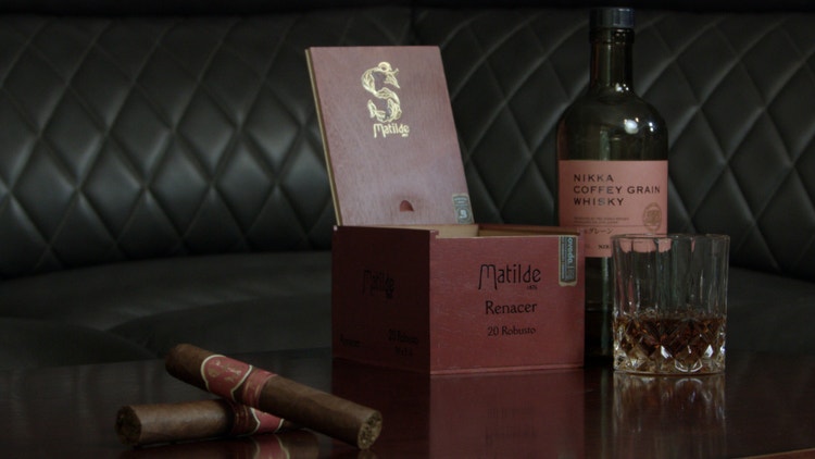 matilde robusto cigars shown on a table next to their open box and bottle and glass of nikka coffey grain whisky