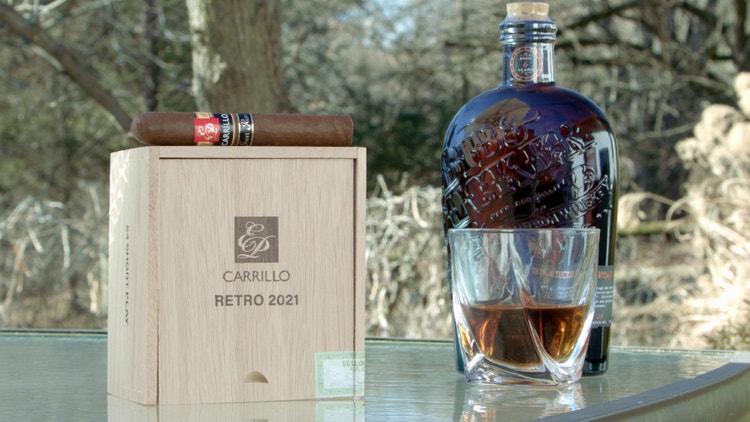 cigar advisor #nowsmoking cigar review e.p. carrillo retro 2021 - setup shot of cigar on box with whiskey bottle and glass