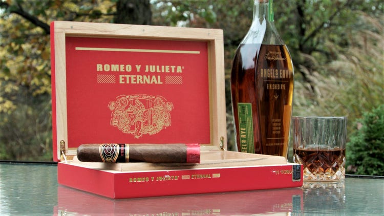 cigar advisor #nowsmoking cigar review of romeo y julieta eternal - setup shot with cigar on box next to bottle of whiskey
