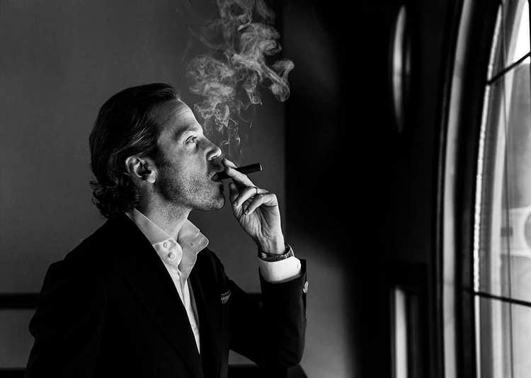 cigar advisor top new cigars - ferio tego edition may 30, 2022 - black and white photo of michael herklots smoking a cigar