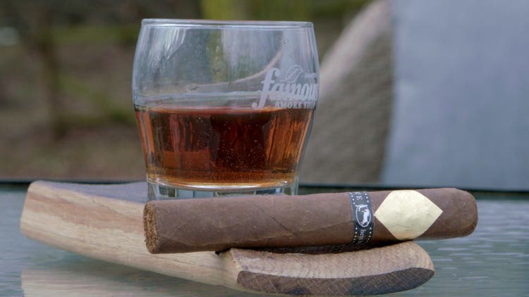 cigar advisor #nowsmoking cigar review cavalier black serie ii - setup shot of cigar with a glass of whiskey in the background